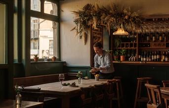 Interior of the Marlborough with tables being set and the bar behind