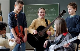 children holding guitars