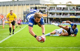 a man diving with a rugby ball