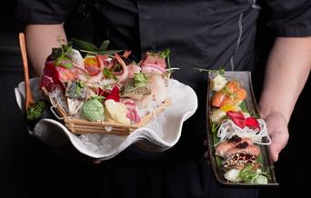 Person holding Sashimi & Nigiri sets