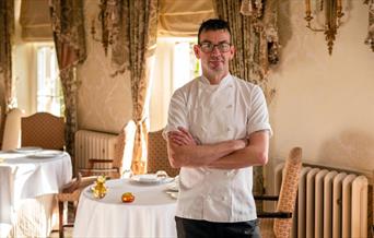 A man wearing a chef's uniform with his arms folded at the Restaurant Hywel Jones in Lucknam Park, near Bath