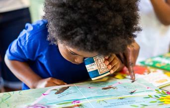 child looks closely at picture map