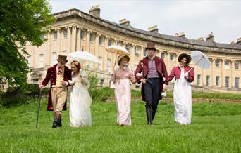 A grpoup of people wearing Regency costume at the Royal Crescent in Bath