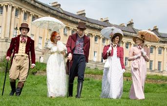 Five people walking in front of Bath's Royal Crescent wearing period dress