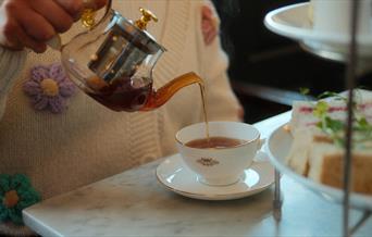 Person pouring tea