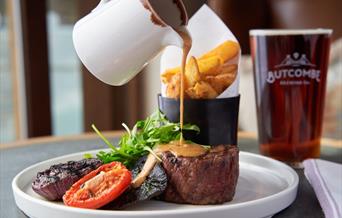 Sauce being poured over steak