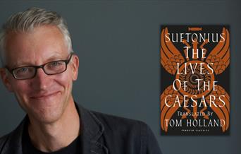 A man smiling against a black background alongside a book cover.