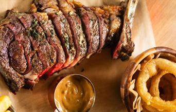 Cote de boeuf with pepper sauce and onion rings