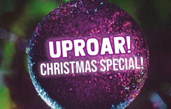 A purple Christmas ornament with the Uproar! logo