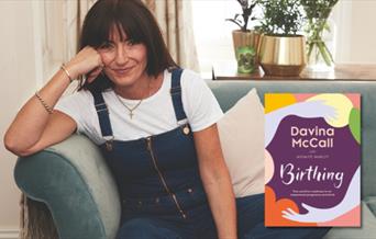 Davina McCall smiling next to her book