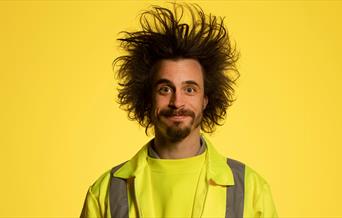 A photo of Viggo Venn in a yellow high vis jacket again a yellow background