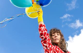 Woman holding balloons in the sky