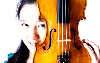 Leia Zhu hiding behind a violin