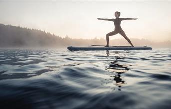 Woman balancing on a surfboard in the sea