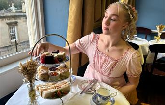 Lady having afternoon tea whilst dressed in period costume