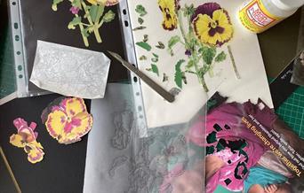 Image of a collage in process across a workspace