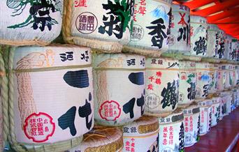 A colourful wall of large, round, traditional sake containers