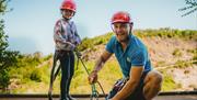 A young girl and an activity leader getting ready to abseil