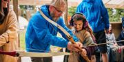 Instructor showing a girl how to do archery