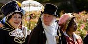 A man flanked by two women all wearing Jane Austen-themed costumes