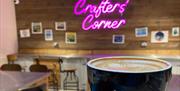 Crafter's Corner neon sign, coffee in front