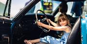 Child sitting in car at Haynes International Motor Museum