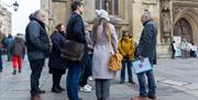 A group of people on a free walking tour of Bath outside Bath Abbey as part of the annual World Heritage Day event