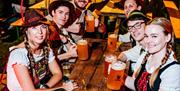 people in german outfits sipping beer