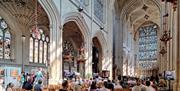 People sat in Bath Abbey listening to a music act