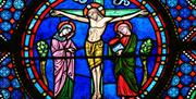 Colourful stained glass depiction of Jesus on the crucifix