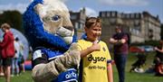 A child with Max the mascot at Bath Rugby's Season Launch event.