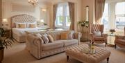 A photograph of a room at Bathen House Hotel including the bath, a couch, and several lounge chairs.