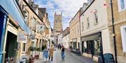 A street in Cirencester with bunting overhead and the Parish of Cirencester behind