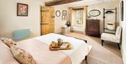 Dovecote's interior - a shot of the cosy bedroom and a tray of breakfast.