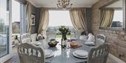 Merryfields interior. A round table set up for a meal with a view outside.
