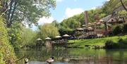Outdoor seating along the riverside at Cross Guns at Avoncliffe