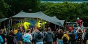 People stood in a field with a stage in the backgroun