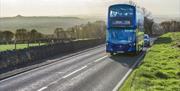 A blue and beige coloured 376 bus from First Bus travelling through Somerset countryside.