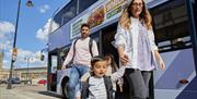 A family disembarking a bus at Bristol Temple Meads railway station