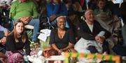 A group of people audience members smiling at the Garden Theatre Festival in Bath.