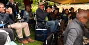Two audience members applauding at the Garden Theatre Festival in Bath.