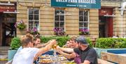 A group of men clinking glasses outside Green Park Brasserie