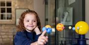 A girl exploring a model of the planets at The Herschel Museum of Astronomy, Bath