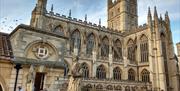 The exterior of Bath Abbey with a blue sky above.