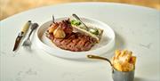 Steak and chips on a table at the Iford Manor Kitchen