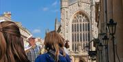 Tour guide discussing the Roman Baths while in front of the Cathedral