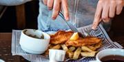 Shot of person eating fish and chips
