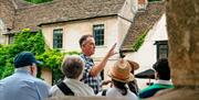 Tour guide presenting to their group in a village in the Cotswolds