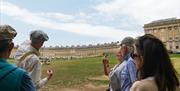 Tour guide presenting and discussing the royal crescent with their group
