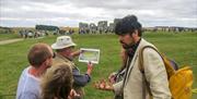 Jules presenting and discussing Stonehenge with a tour group